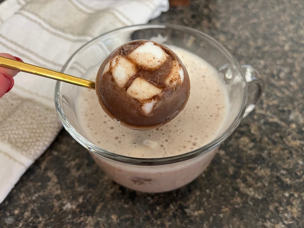 Image of cocoa bomb on top of hot cocoa mug